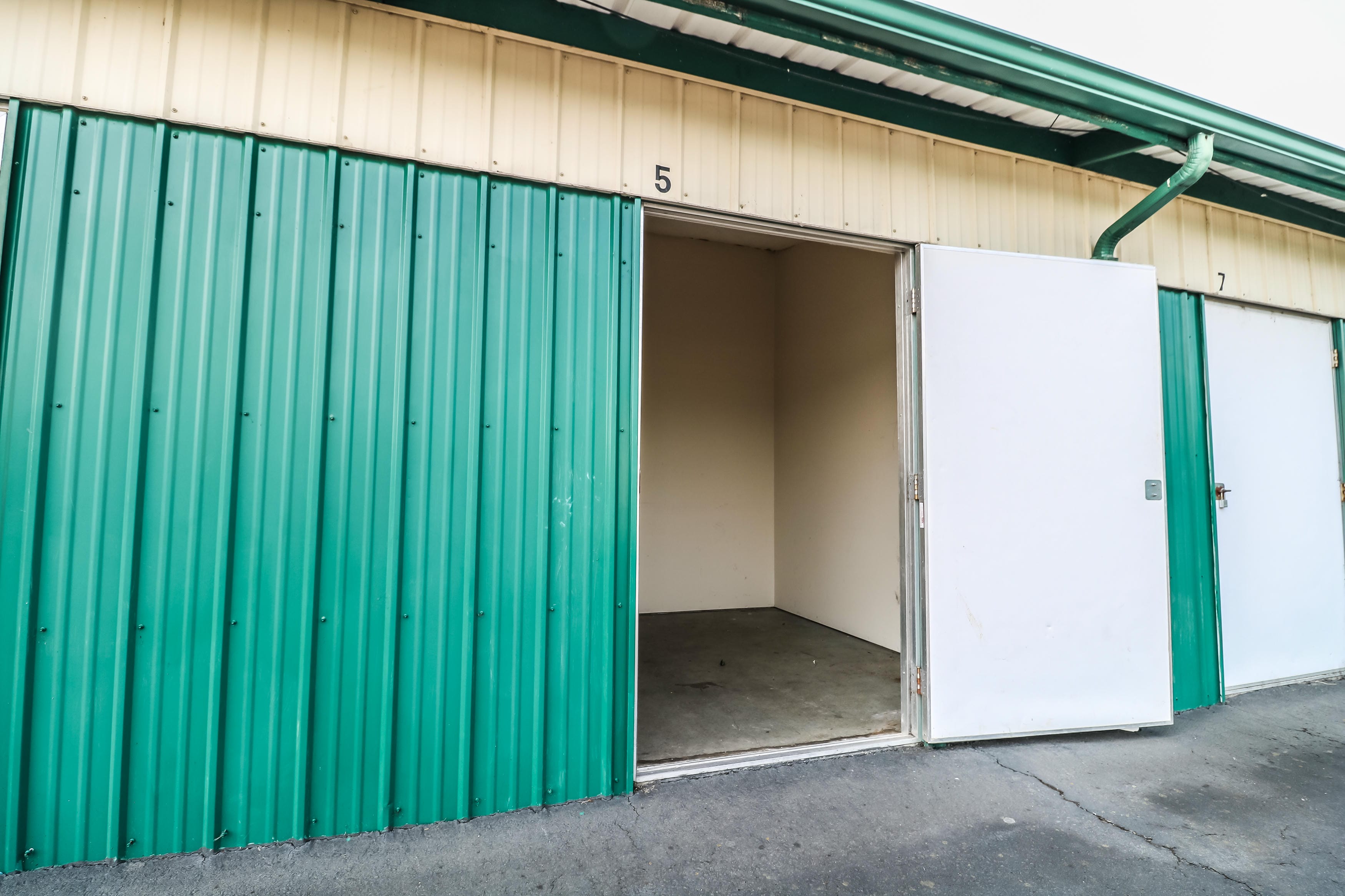 Open 10 by 10 drive-up storage unit with a swing-open door, showing a clean empty interior at Ocean Beach Self Storage